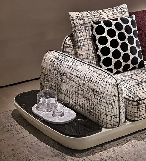 Détail de canapé en tissu chiné écru et noir, tablette en marbre intégrée