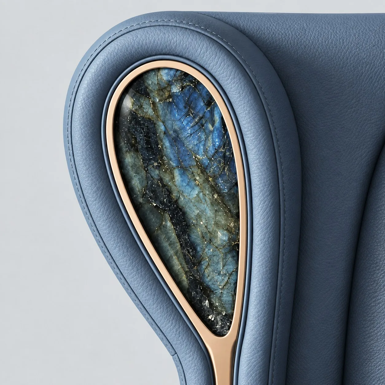 Détail de fauteuil en cuir bleu-gris, médaillon en pierre veinée et laiton doré